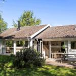 Wohnhaus mit Terrasse, Grillplatz und Garten. Fenster zeigen Wohn- und Essbereich.