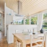 Küche mit Essbereich, Holzdecke und großem Fenster zum Garten.