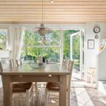 Esszimmer mit Holztisch, Stühlen und Blick auf Garten.