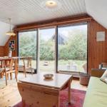 Wohn- und Essbereich mit Holzmöbeln und großen Fenstern zum Garten.