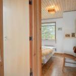 Schlafzimmer mit Bett, Stuhl und Fenster. Holzwände und Decke.