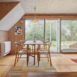 Esszimmer mit Holztisch, Stühlen und Glasfront zum Garten