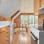 Küche mit Holzwand und Blick auf Essbereich mit Tisch und Stühlen.