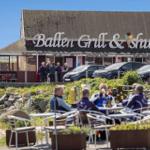 Außenbereich mit Tischen und Stühlen vor einem Restaurant.