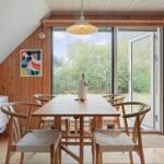 Essbereich mit Holztisch, Stühlen und Glasfront zur Außenterrasse.