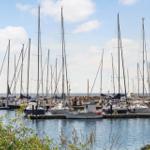 Marina mit vielen Segelyachten und kleineren Booten an Stegen