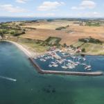 Hafen mit Booten, Strand und umliegenden Feldern.