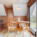 Essbereich mit Holztisch und Stühlen, große Glasfront zum Garten