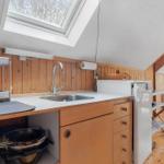 Küche mit Dachschräge, Holzwand und Fenster