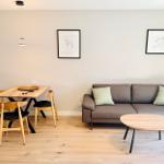 Wohn- und Essbereich mit Sofa, Tisch und Stühlen an Holzboden.