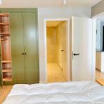 Schlafzimmer mit grünem Schrank, Blick in Bad und Küche