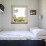 Bedroom with bed, window, and wall pictures.
