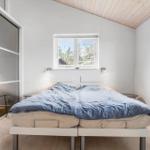 Schlafzimmer mit Doppelbett, Fenstern und Spiegelschrank.