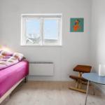 Ein Zimmer mit Bett, Fenster, Tisch und Stuhl.