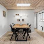 Esszimmer mit Holzboden, Tisch und Stühlen, Deckenlicht und Fenster.