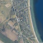 Satellitenbild von Küstenortschaft mit Häusern und Feldern