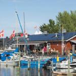 Hafen mit Booten und Café unter dänischen Flaggen.