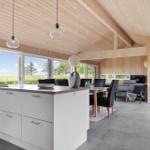 Moderne Küche mit Essbereich und Wohnzimmer mit Holzdecke und großzügigen Fenstern.