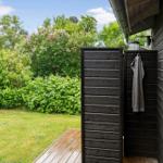 Außen-Dusche neben Haus mit Grünfläche und Bäumen