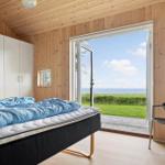 Schlafzimmer mit Blick auf Meer, Bett, Stuhl und Schrank.