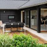 Terrasse mit Tisch, Stühlen und Blick in die Küche.