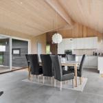 Eingangsbereich mit Essbereich und Küche. Holzdecke und große Fenster.