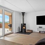 Wohnzimmer mit Kamin, TV und Terrasse mit Grill.
