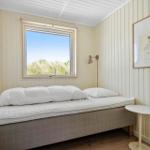 Schlafzimmer mit Bett, Fenster und Wandbild.