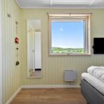 Schlafzimmer mit Fenster, Bett und Fernseher an der Wand.
