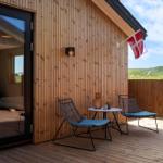 Terrasse mit zwei Stühlen und Tisch, daneben Flagge und Holzwand
