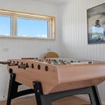 Fussballtisch in einem Raum mit Fenstern und Wandbild.