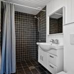 Badezimmer mit Dusche, Waschbecken und Toilette.