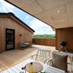 Terrasse mit Sitzgelegenheiten, Grill und Blick auf die Landschaft.
