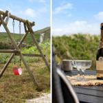 Holzschaukel im Gras und Champagner auf Terrasse mit Blick auf Hügel