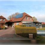 Haus mit Solaranlage, Terrasse und gepflegtem Gartenbereich.