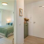 Schlafzimmer mit Bett und Fenster. Flur mit Tür und Körben.