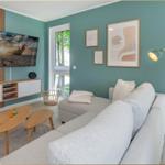 Wohnzimmer mit Sofa, TV und Fenstern