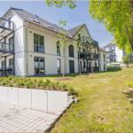 Moderne Wohnanlage mit Balkonen und grünem Außenbereich.