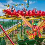 Roter Schmetterlingszug mit Fahrgästen auf gelber Strecke