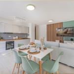 Moderne Küche mit Essbereich und Wohnzimmer mit Sofa und Fernseher.