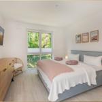 Schlafzimmer mit Bett, Fenster und TV.