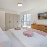 Schlafzimmer mit Bett, Schrank, TV und Balkonzugang.