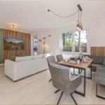 Wohn- und Essbereich mit Sofa, Esstisch und Fenster zur Außenseite.