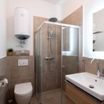 Badezimmer mit Dusche, Waschbecken und Toilette. Moderne Einrichtung.