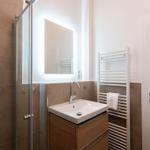 Badezimmer mit Dusche, Waschbecken und Handtuchhalter.