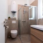 Badezimmer mit Dusche, Waschbecken und Toilette.