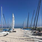 Sailboats stehen auf Sandstrand vor Meer unter blauem Himmel