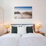 Schlafzimmer mit Bett, Nachttischen und Wandbild