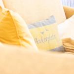 Sofa mit Kissen und Decke, eines mit Aufschrift Ankerplatz.