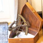 Antikmessinstrument in Holzkiste auf Boden